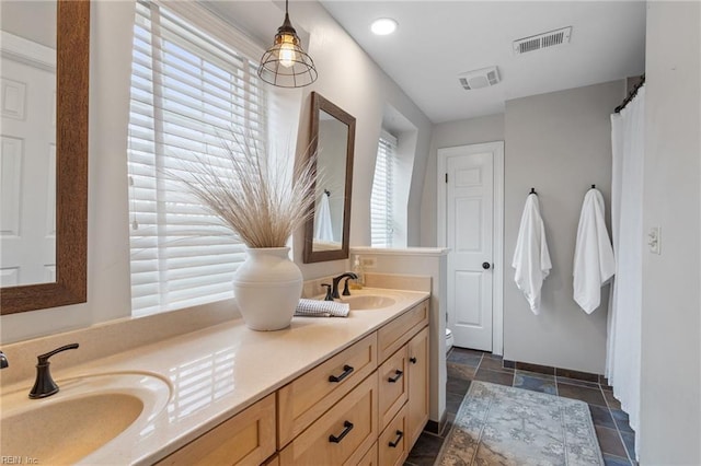 bathroom featuring a sink, visible vents, and double vanity