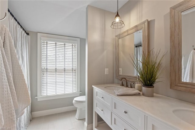 bathroom with tile patterned floors, toilet, a sink, double vanity, and baseboards