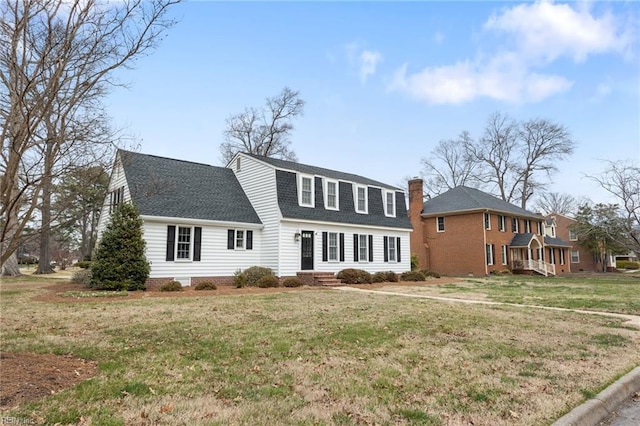 colonial inspired home with a front lawn and roof with shingles