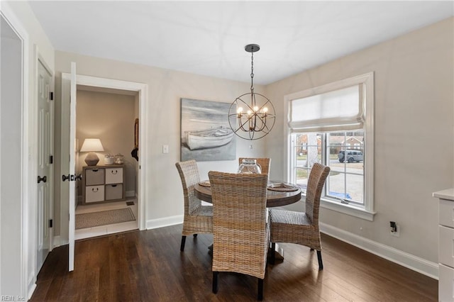 dining space with baseboards, a notable chandelier, and hardwood / wood-style floors