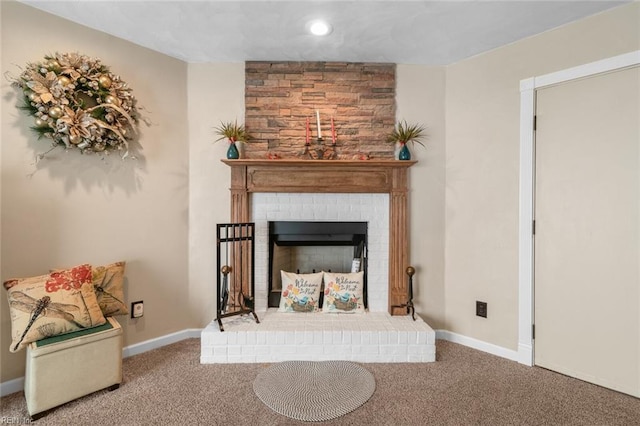 living area featuring a brick fireplace, baseboards, and carpet floors