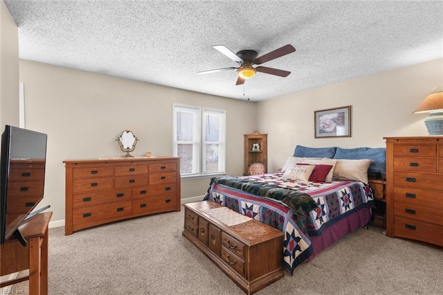 bedroom with baseboards, light colored carpet, ceiling fan, and a textured ceiling