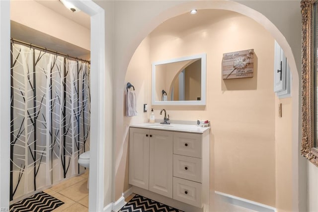 bathroom featuring tile patterned floors, toilet, curtained shower, and vanity