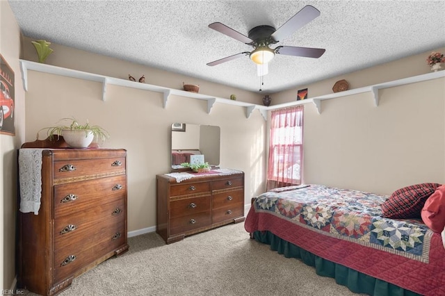 bedroom with a textured ceiling, a ceiling fan, baseboards, and light carpet