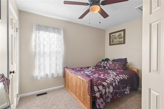 bedroom featuring visible vents, a ceiling fan, a textured ceiling, carpet flooring, and baseboards