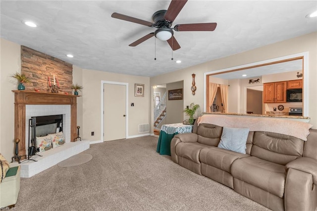 living area featuring stairway, visible vents, recessed lighting, a fireplace, and light colored carpet