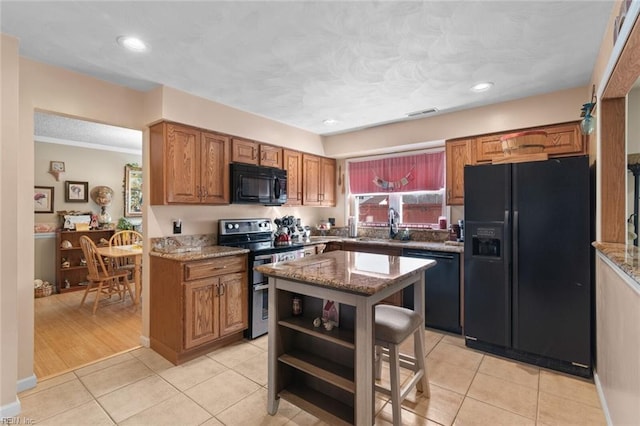 kitchen featuring light tile patterned floors, stone counters, open shelves, black appliances, and brown cabinets