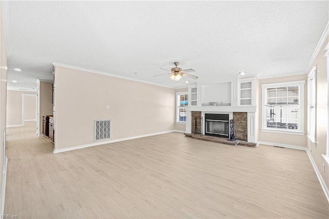 unfurnished living room featuring a ceiling fan, visible vents, ornamental molding, light wood-style floors, and a textured ceiling