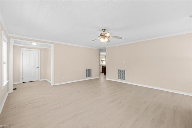 spare room featuring visible vents, light wood-style flooring, a ceiling fan, and ornamental molding