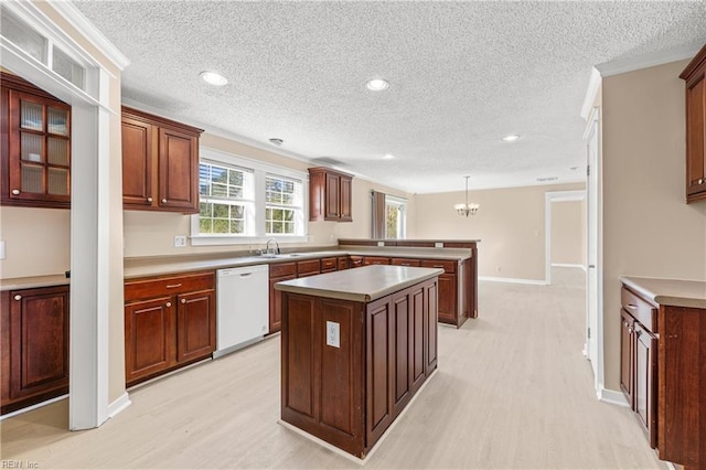 kitchen featuring light wood-style flooring, a center island, a peninsula, an inviting chandelier, and white dishwasher