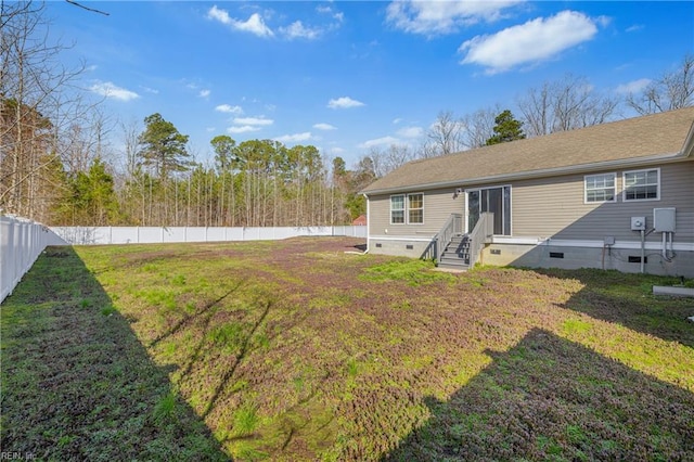 view of yard featuring entry steps and a fenced backyard