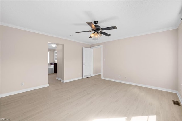 empty room featuring crown molding, a ceiling fan, light wood-type flooring, and visible vents