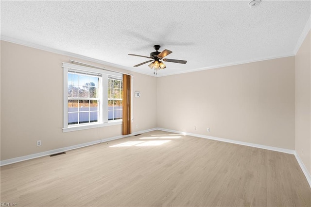 empty room featuring crown molding, visible vents, light wood finished floors, and ceiling fan