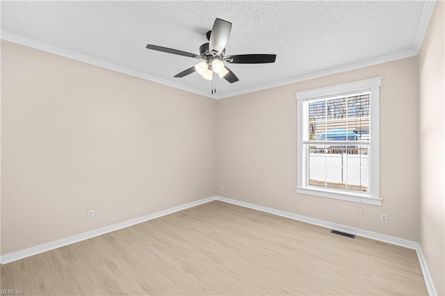 spare room featuring visible vents, light wood-style floors, baseboards, and a textured ceiling