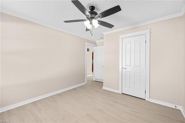 unfurnished bedroom with light wood-style flooring, ornamental molding, baseboards, and a textured ceiling