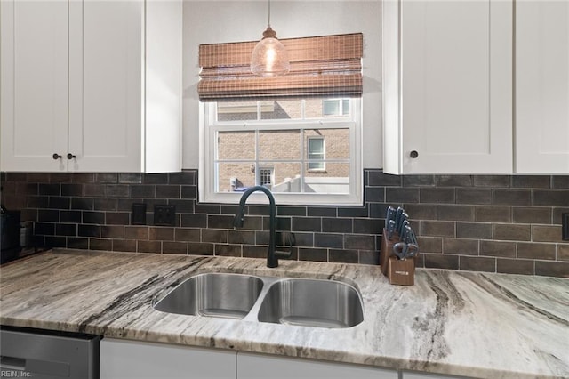 kitchen featuring a sink, decorative backsplash, and white cabinets