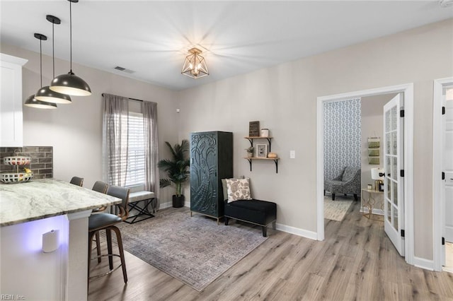 interior space with light wood-style flooring, baseboards, and visible vents