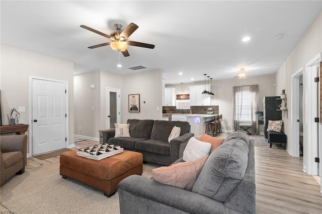 living room featuring recessed lighting, light wood-style flooring, baseboards, and ceiling fan