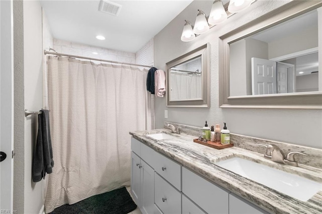 bathroom with a sink, visible vents, a shower with curtain, and double vanity