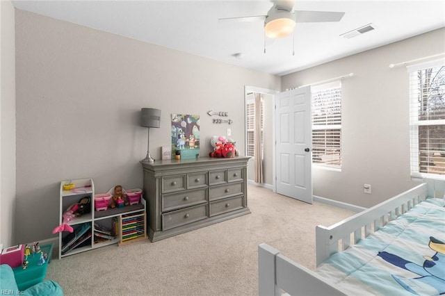 carpeted bedroom with visible vents, a ceiling fan, and baseboards