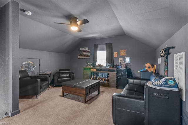 living area with a textured ceiling, a ceiling fan, carpet, and vaulted ceiling