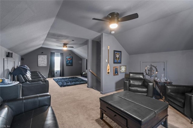 home theater room with lofted ceiling, a ceiling fan, carpet floors, and a textured ceiling