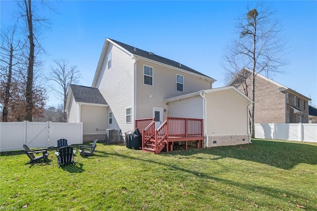 rear view of property featuring a yard, a wooden deck, and a fenced backyard