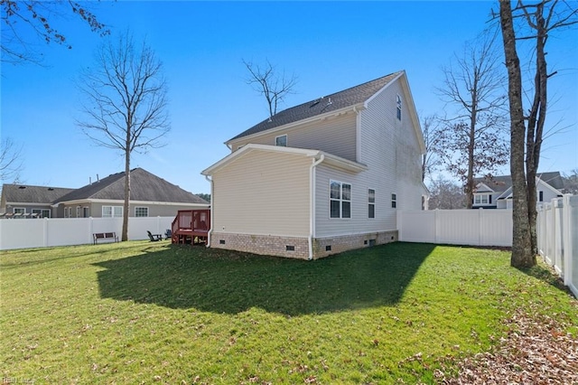 back of house with crawl space, a lawn, and a fenced backyard