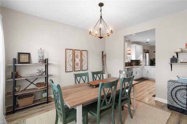 dining area featuring recessed lighting, baseboards, light wood-type flooring, and a chandelier