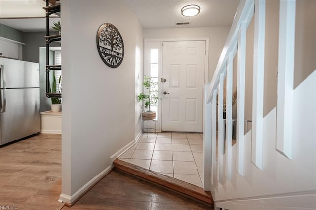 entryway with baseboards, wood finished floors, and stairs