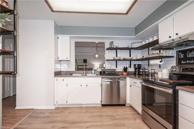 kitchen with a sink, open shelves, light wood-type flooring, and appliances with stainless steel finishes