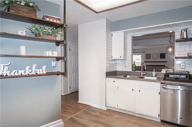 kitchen with a sink, open shelves, stainless steel dishwasher, white cabinets, and light wood finished floors