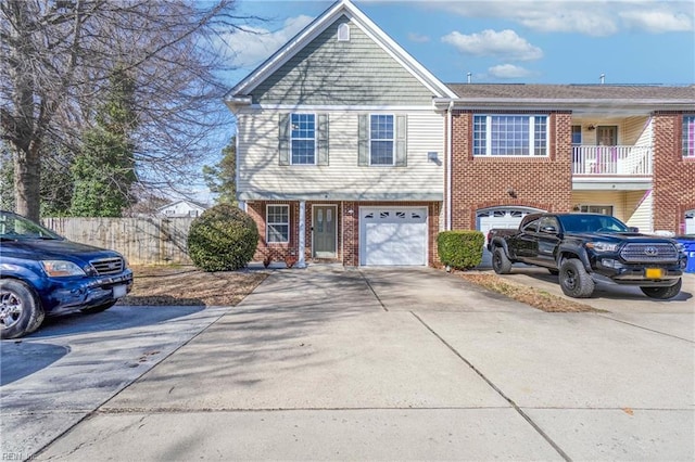 view of front of home with a garage, brick siding, concrete driveway, and fence