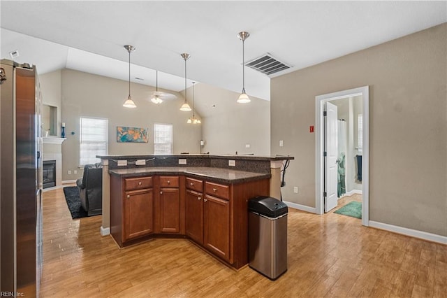 kitchen featuring visible vents, pendant lighting, light wood-type flooring, and open floor plan