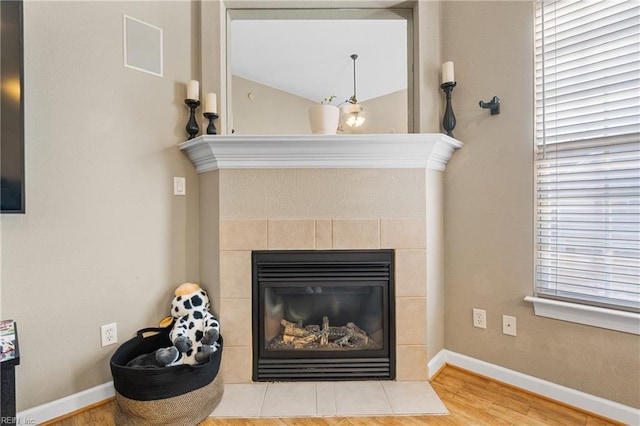 interior details featuring wood finished floors, baseboards, and a tile fireplace