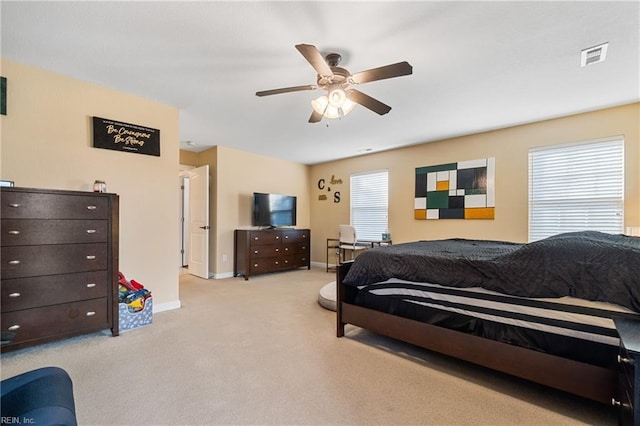 carpeted bedroom featuring visible vents, a ceiling fan, and baseboards