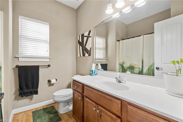 full bath with curtained shower, baseboards, toilet, wood finished floors, and vanity