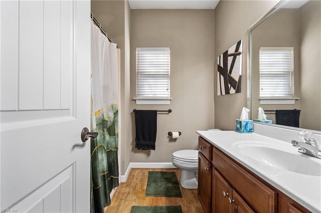 bathroom featuring toilet, curtained shower, wood finished floors, baseboards, and vanity