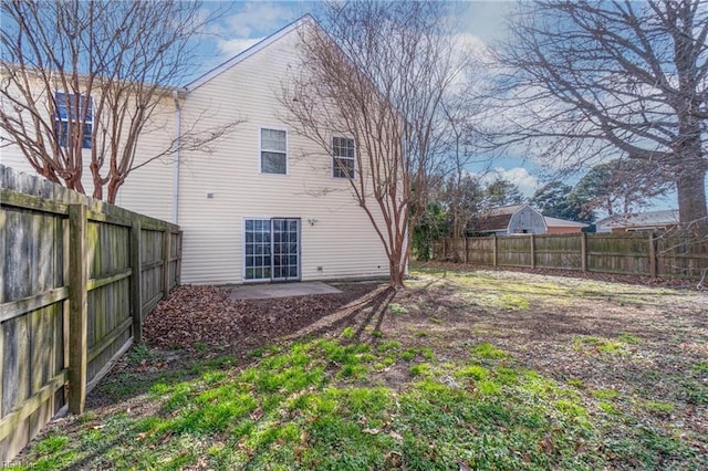 back of house with a fenced backyard and a patio area