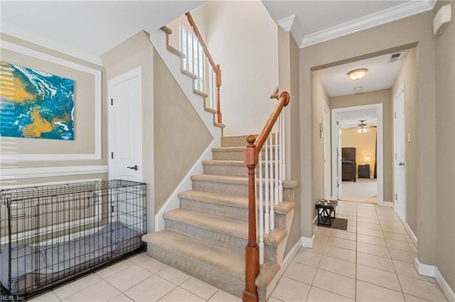 stairs with tile patterned floors, ceiling fan, baseboards, and ornamental molding