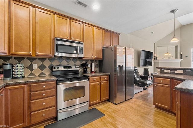 kitchen featuring dark countertops, visible vents, appliances with stainless steel finishes, and brown cabinets