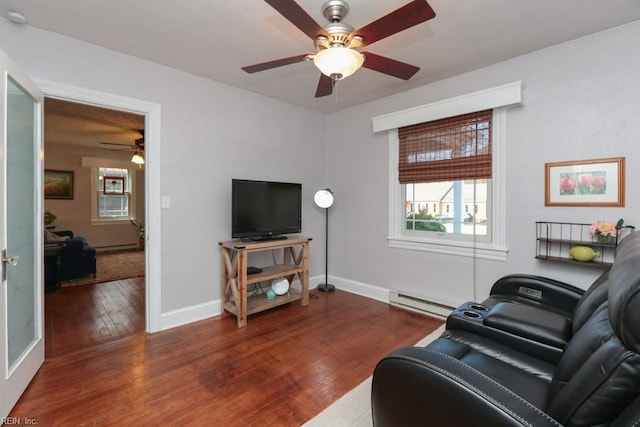 living room featuring wood-type flooring, baseboards, baseboard heating, and ceiling fan