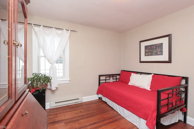 bedroom featuring wood finished floors, baseboards, and a baseboard radiator