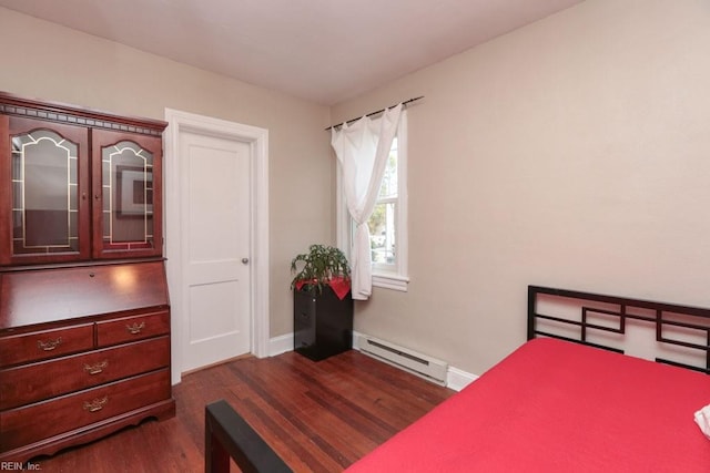 bedroom featuring baseboard heating, baseboards, and dark wood-style flooring