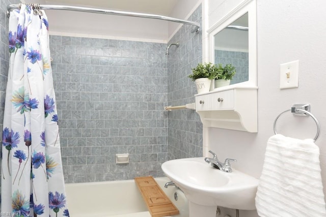 bathroom with a sink and shower / bathtub combination with curtain