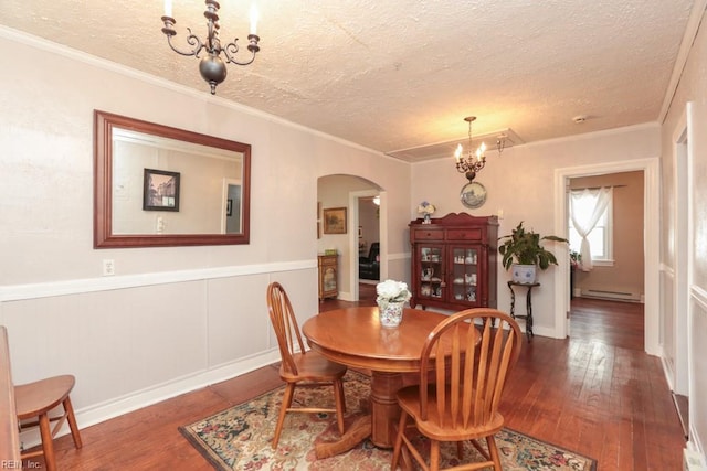 dining room featuring arched walkways, a notable chandelier, a baseboard heating unit, and hardwood / wood-style floors