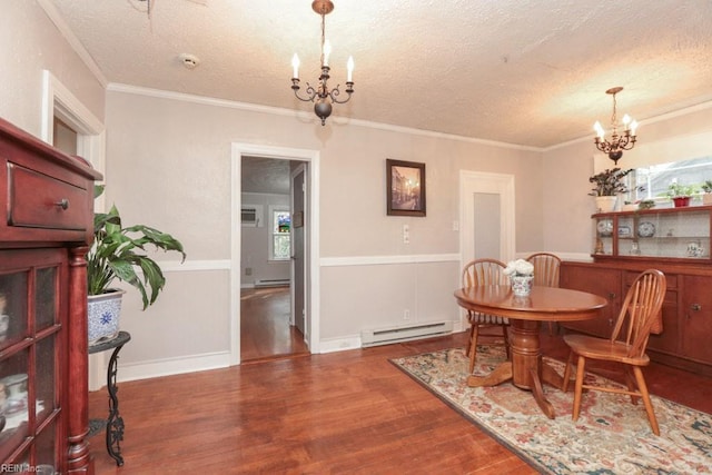 dining area with a baseboard heating unit, an inviting chandelier, wood finished floors, and ornamental molding