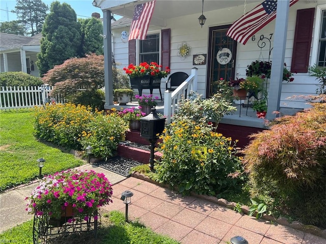 exterior space featuring a porch and fence