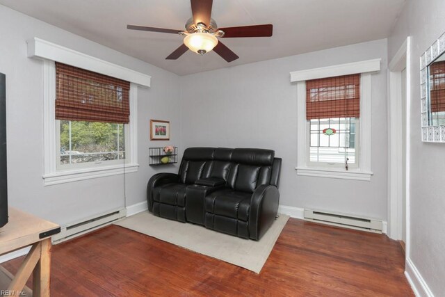 living area featuring ceiling fan, a baseboard heating unit, and baseboards