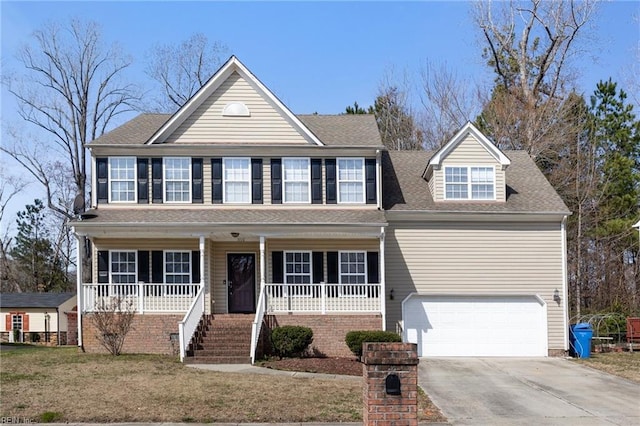 view of front of home with a porch, roof with shingles, concrete driveway, a front yard, and a garage